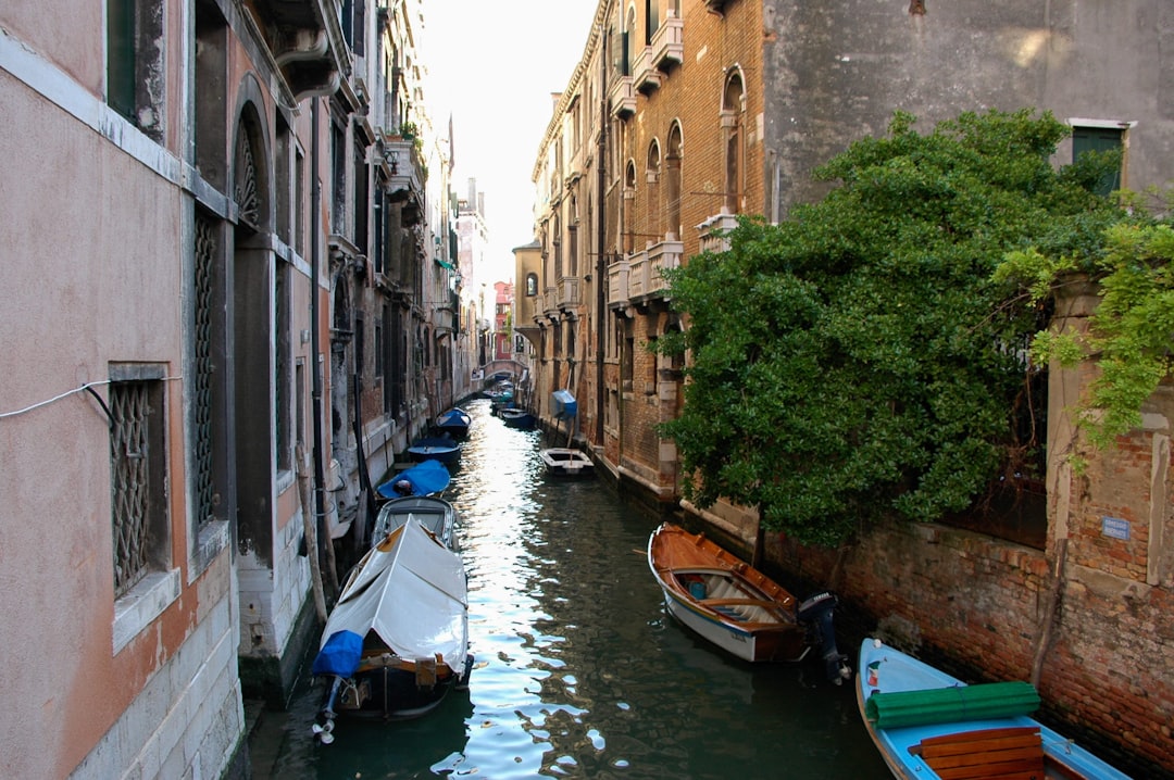 a narrow canal with several boats in it,
