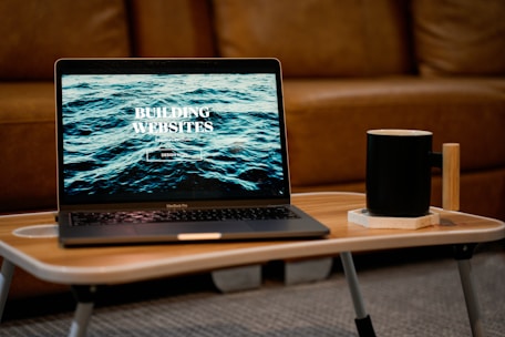 a laptop computer sitting on top of a wooden table