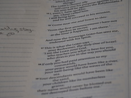 A close-up of a page from a book with text printed in a serif font. There are handwritten notes on the left margin, while the right side contains printed passages. The text is aligned in two columns.