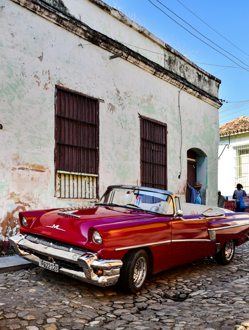 a red car parked in front of a white building