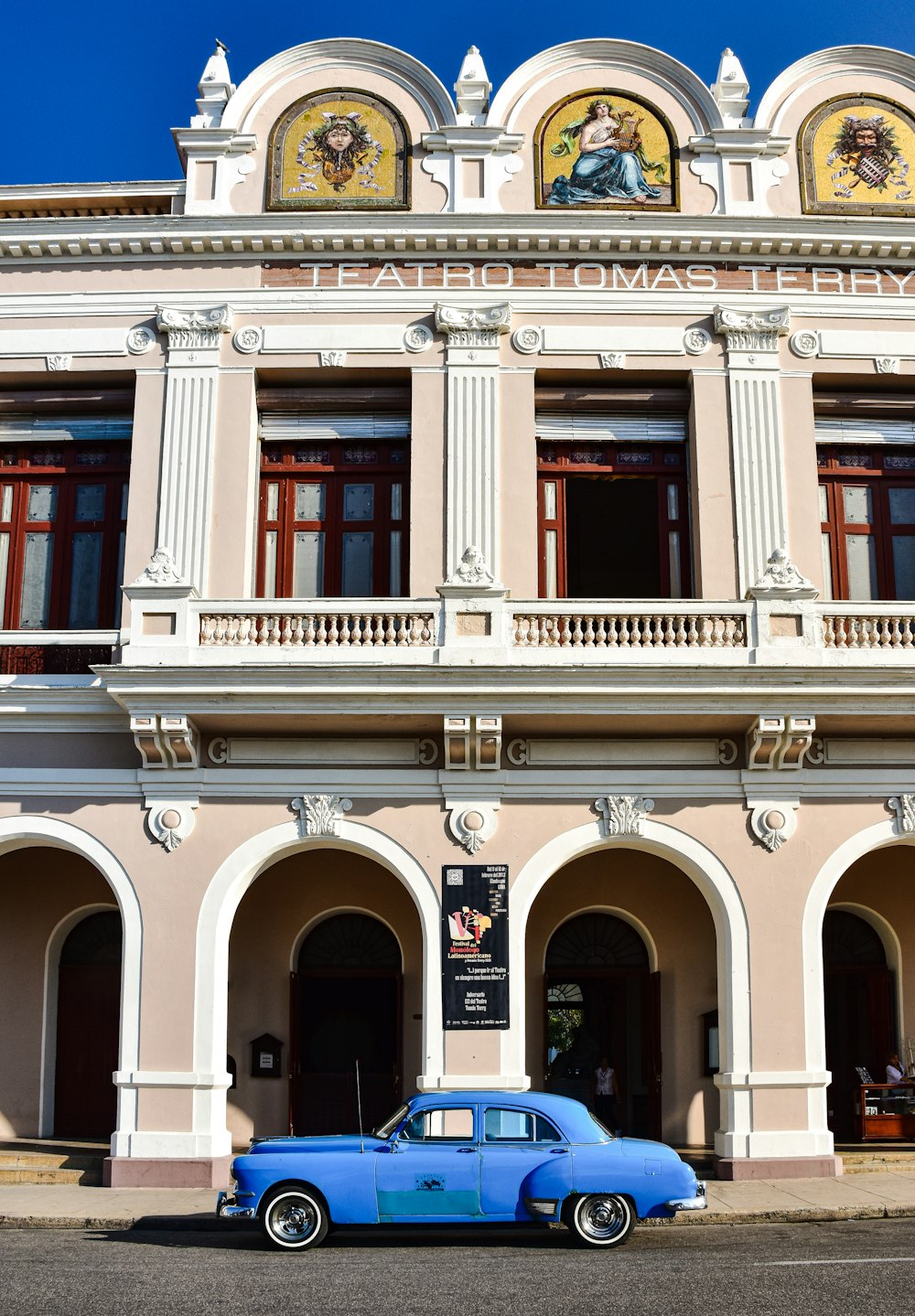 a blue car parked in front of a building