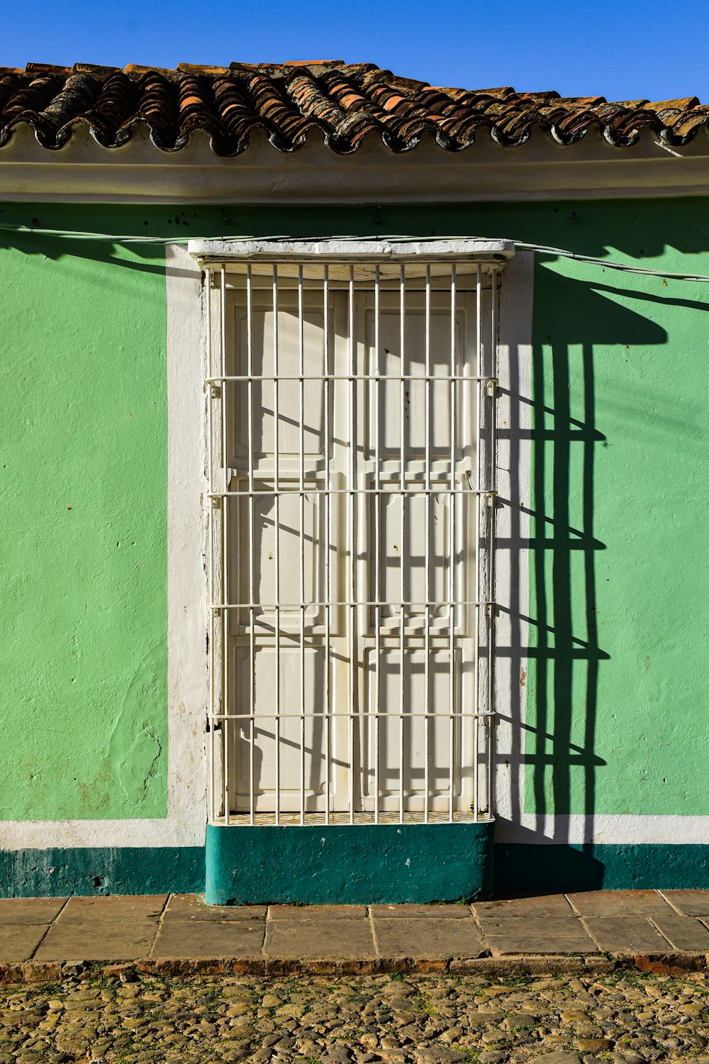 a green building with a white door and window