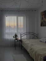 Cozy bedroom adorned with layered curtains combining texture and warmth.