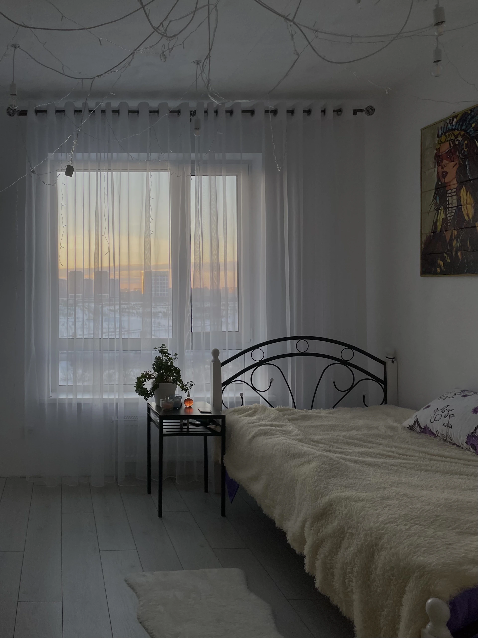 Cozy bedroom with soft natural light filtering through sheer curtains, vintage wooden furniture, and a touch of fresh flowers on the bedside table.
