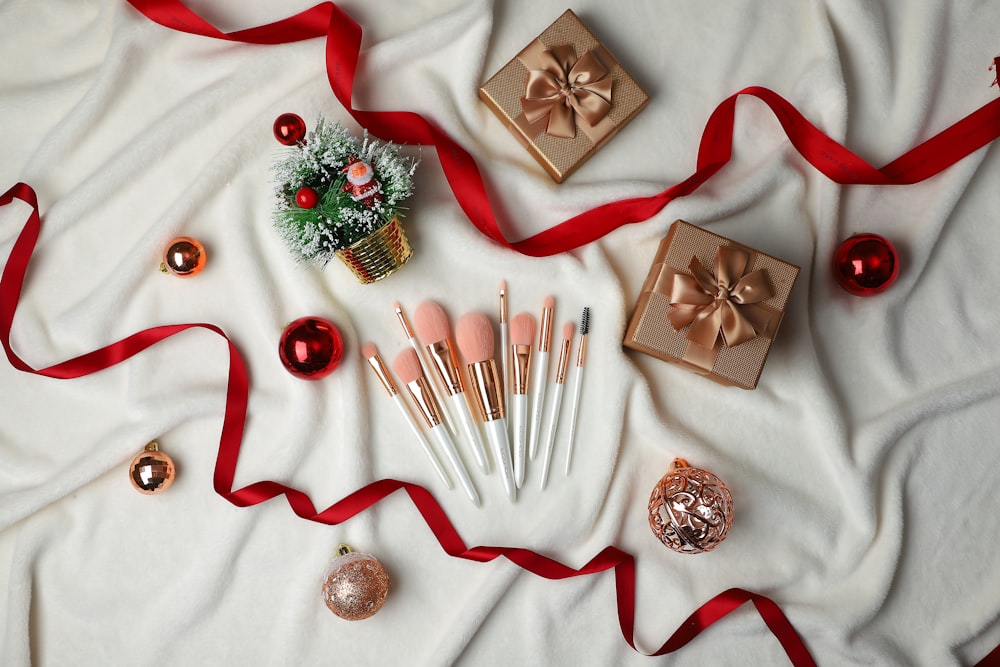 a white sheet with a red ribbon and a set of makeup brushes