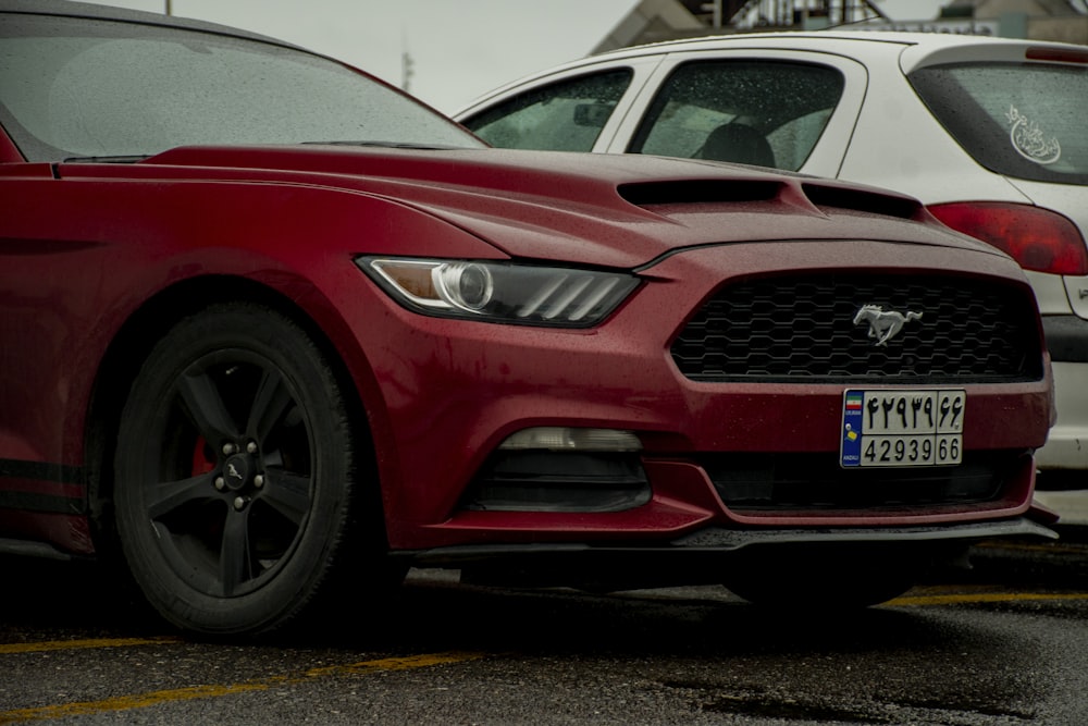 a red mustang parked in a parking lot