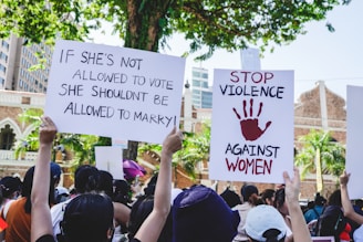 a group of people holding up signs in front of a building