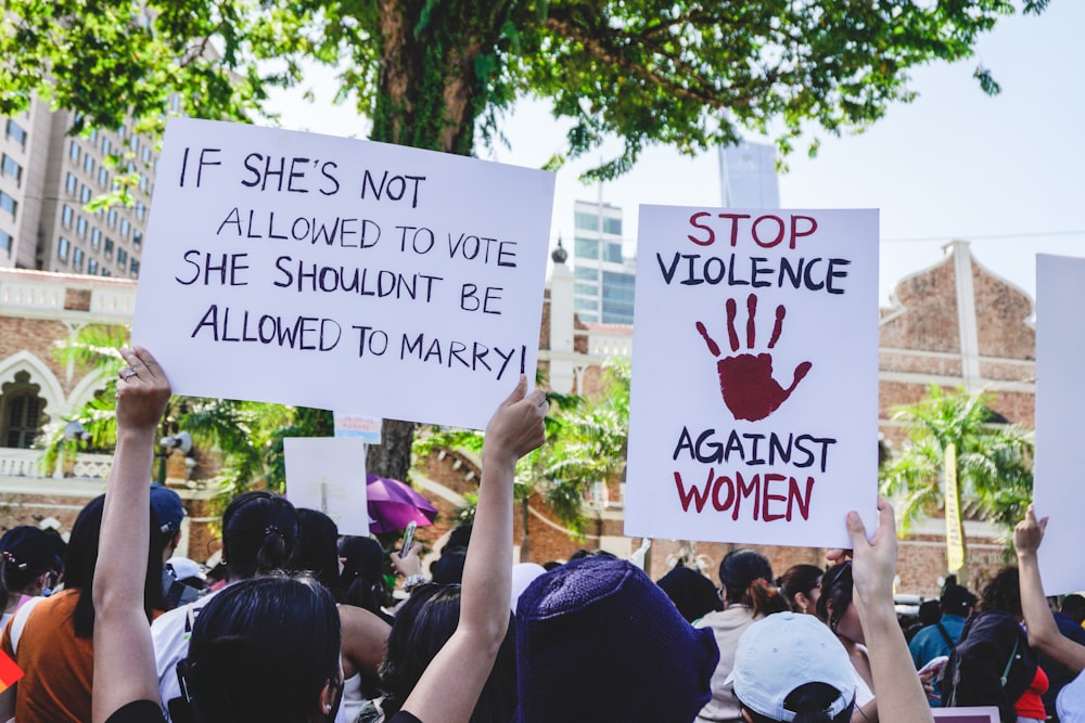 a group of people holding up signs in front of a building