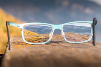 Cycling glasses resting on a mountain trail bench with a scenic view in the background
