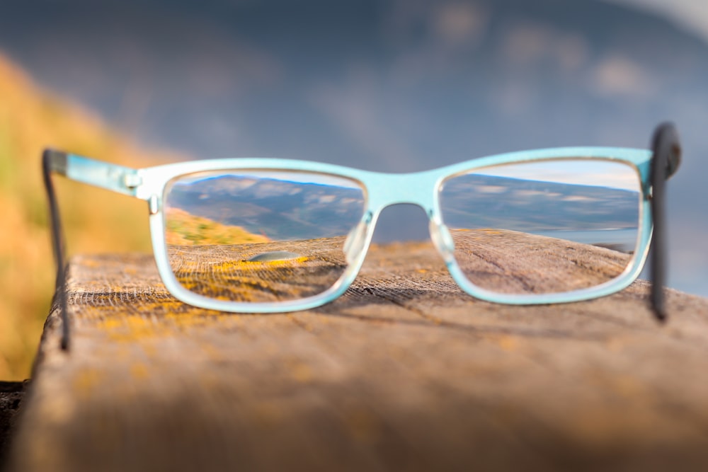 a pair of glasses sitting on top of a wooden table