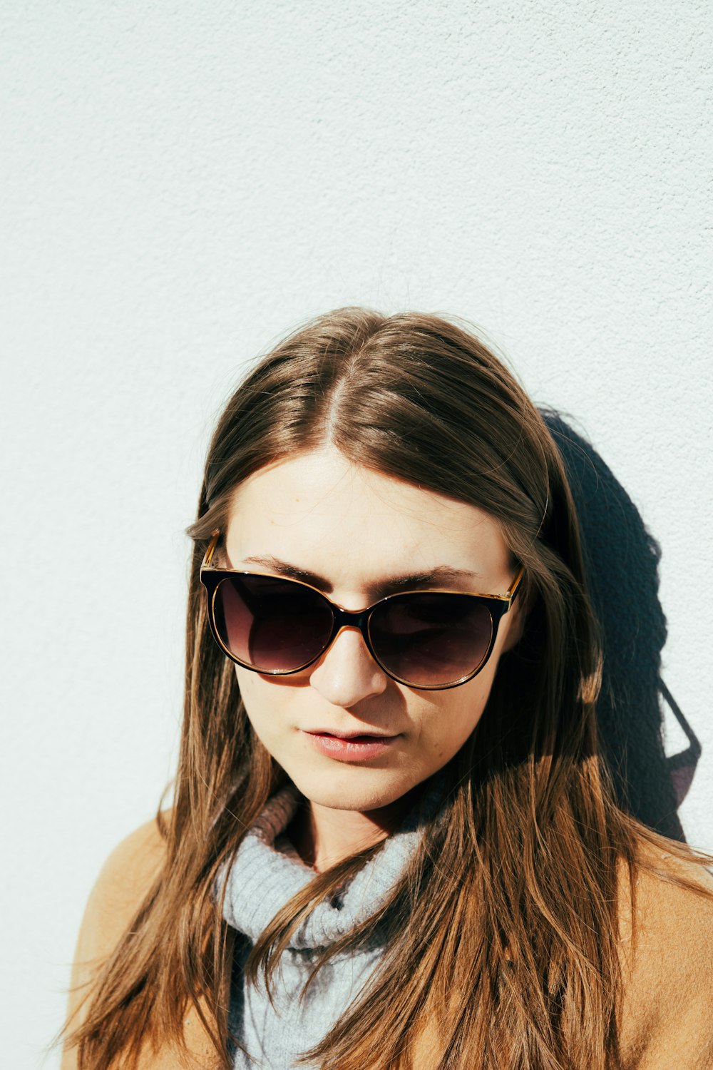 a woman wearing sunglasses and a scarf