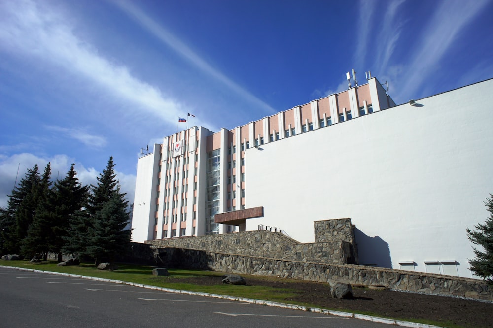 Un alto edificio blanco sentado junto a un exuberante bosque verde