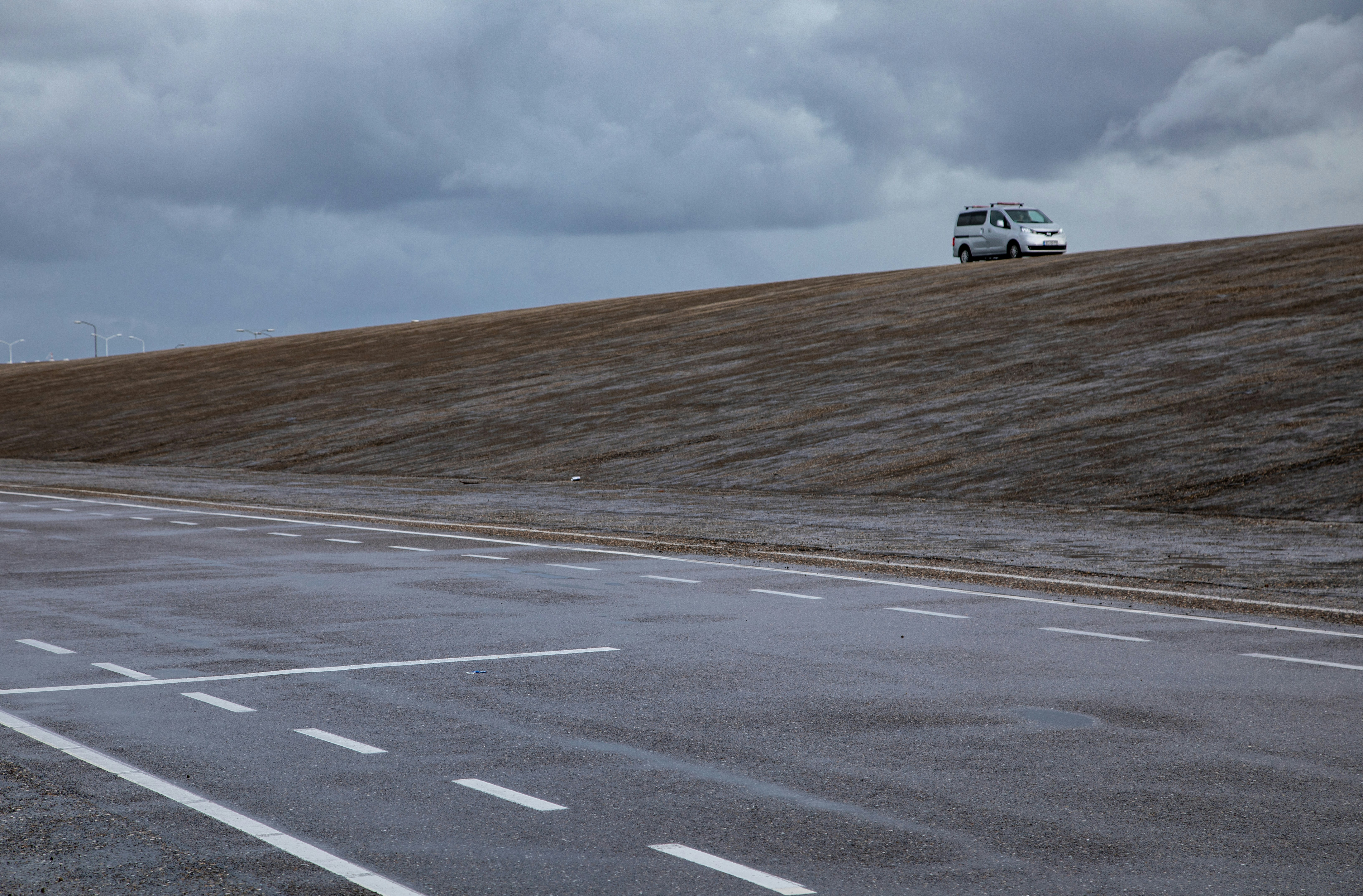 a white van driving down a road next to a field