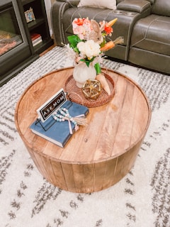 A cozy living room featuring a round accent table with a vase of fresh flowers.