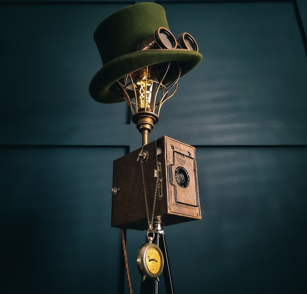 a green hat on top of an old fashioned camera