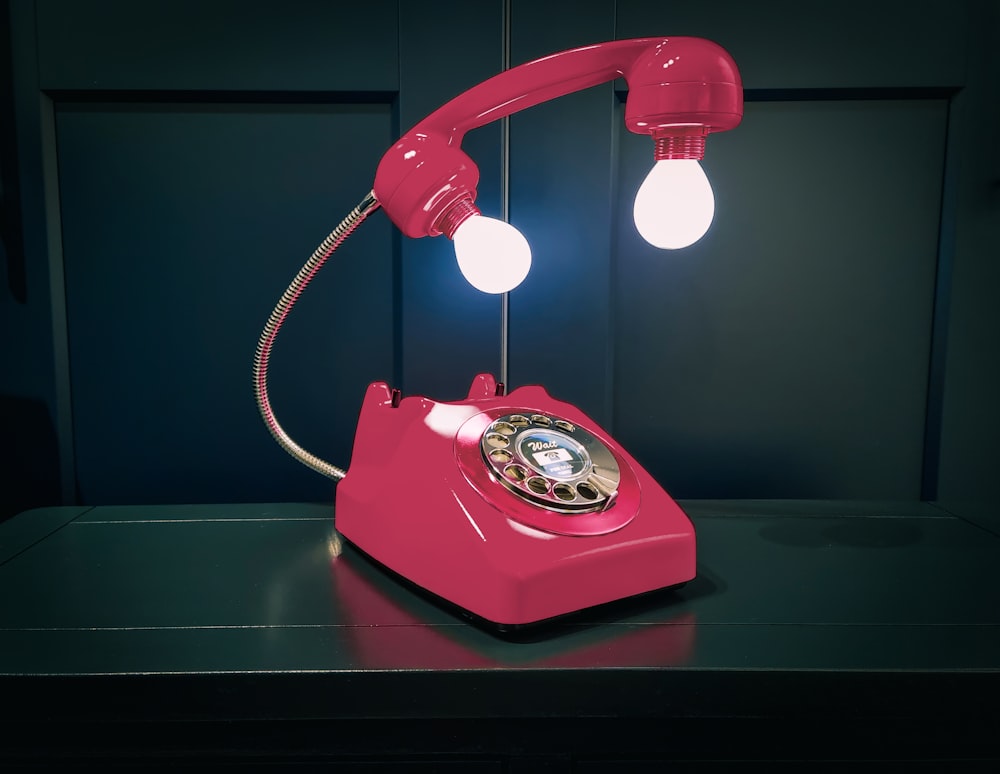 a red telephone sitting on top of a table