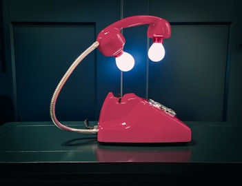 a pink telephone sitting on top of a table