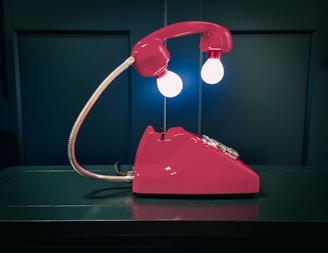 a pink telephone sitting on top of a table