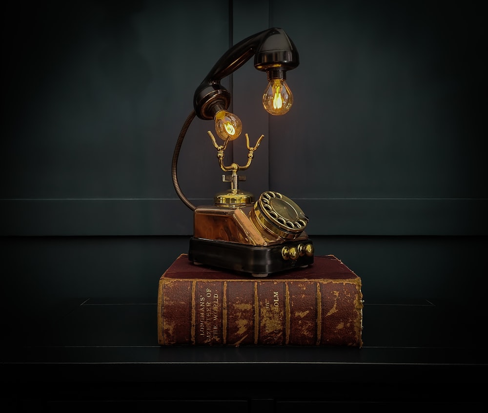 an old fashioned telephone sitting on top of a book