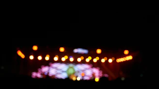 Close-up of colorful event tickets with a blurred stage background.