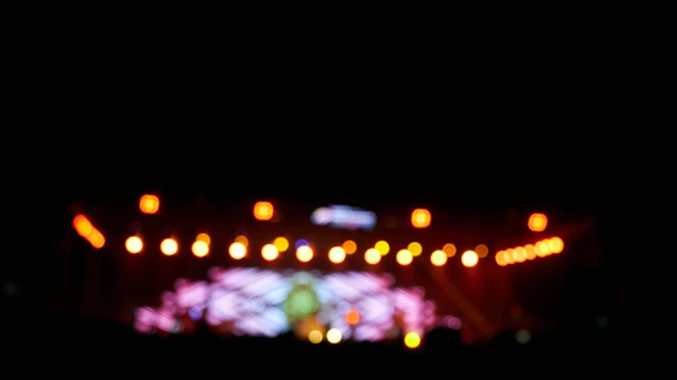 Close-up of colorful event tickets with a blurred stage background.