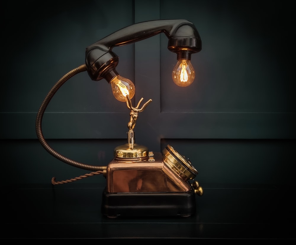 an old fashioned telephone with a light bulb on top of it