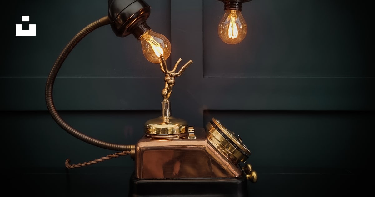 An old fashioned telephone with a light bulb on top of it photo – Free ...