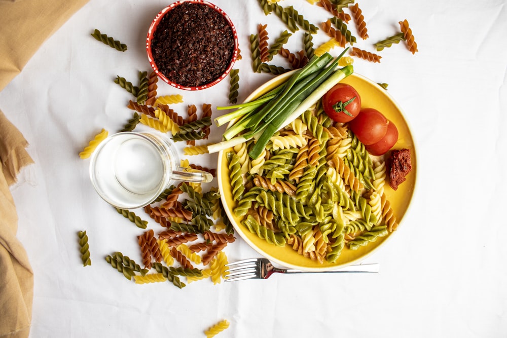 a plate of pasta with green beans and tomatoes