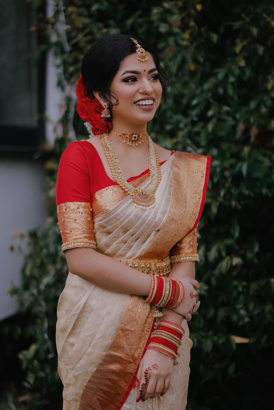 Bride in a gold-bordered silk saree with temple jewellery and jasmine in her hair