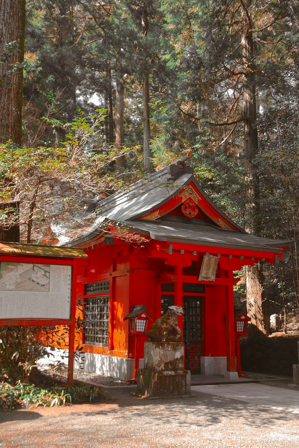 a small red building in the middle of a forest