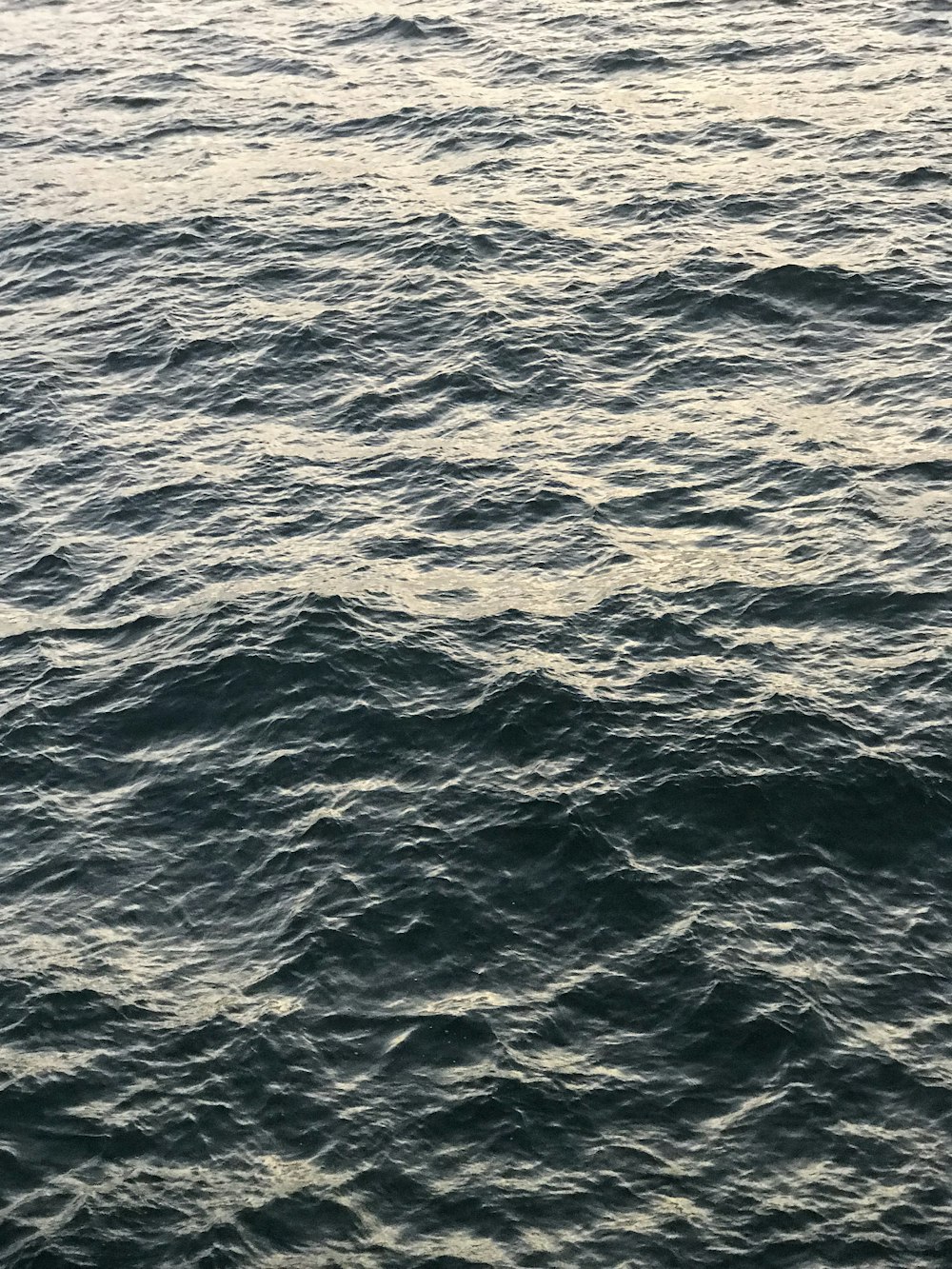 a large body of water with a boat in the distance