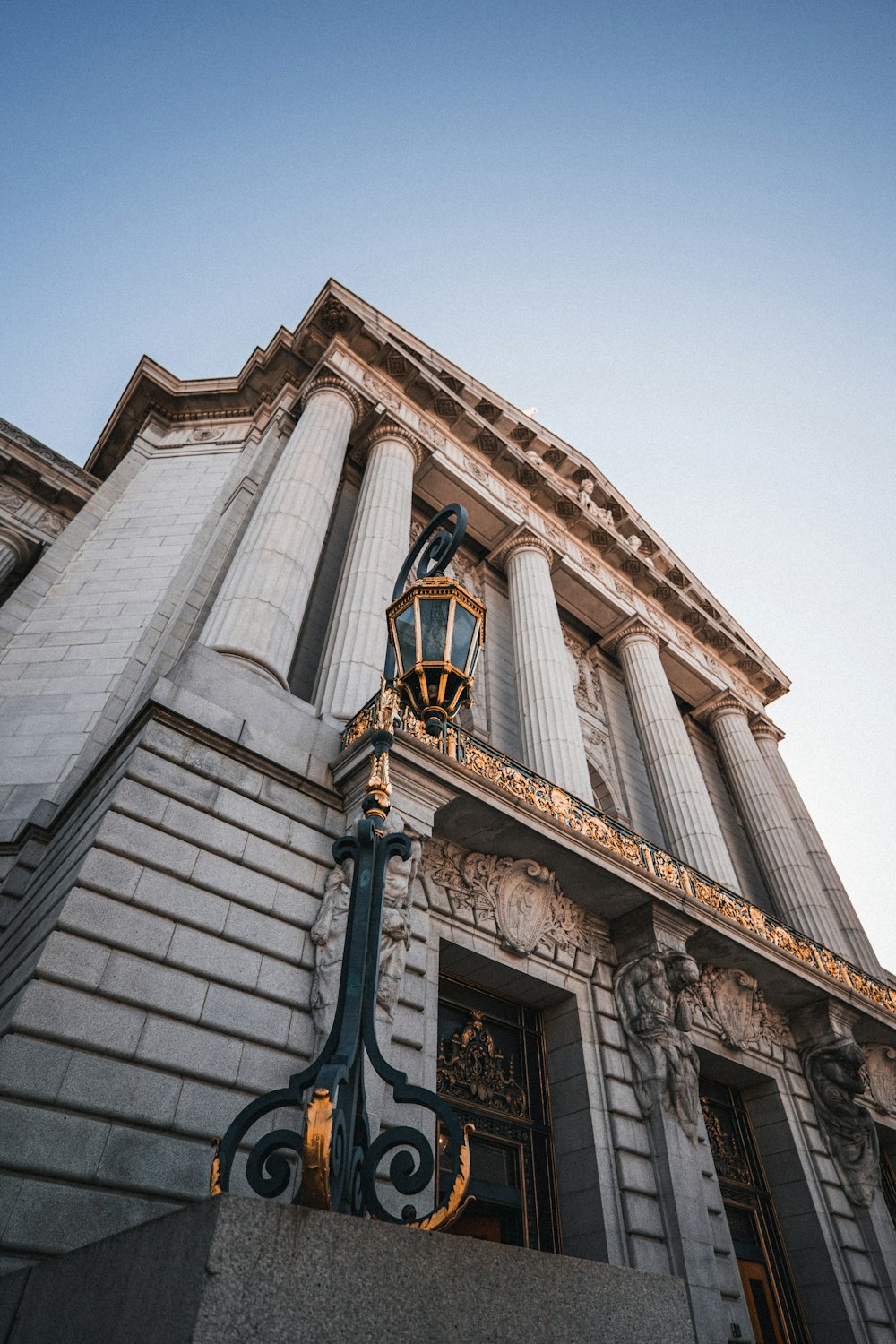 a tall building with columns and a street light