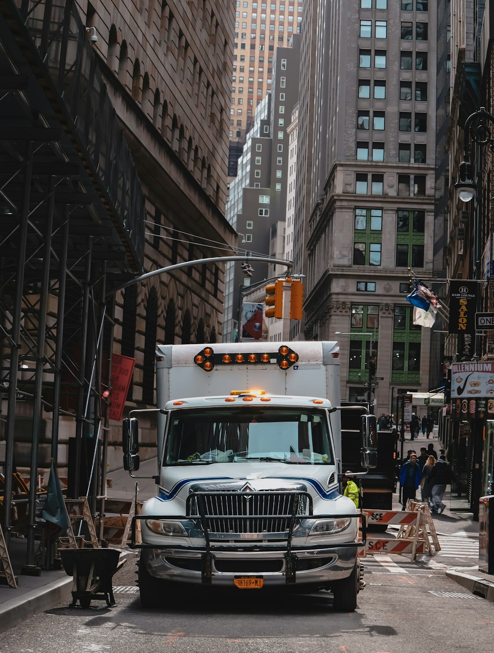 a large truck driving down a street next to tall buildings