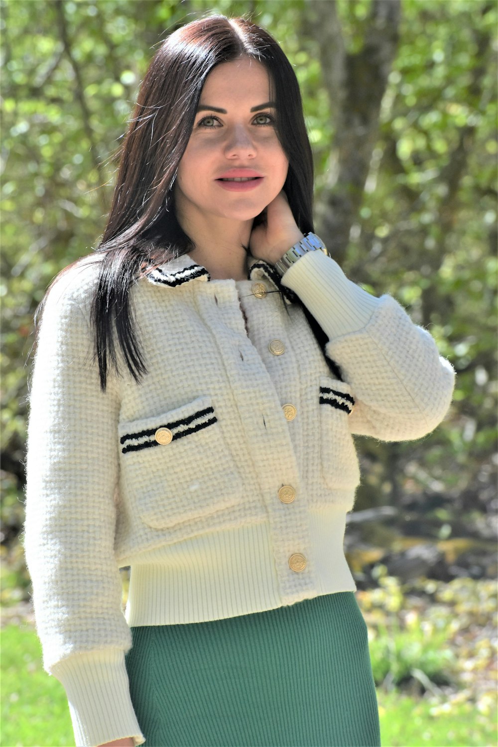 a woman in a white sweater and green skirt