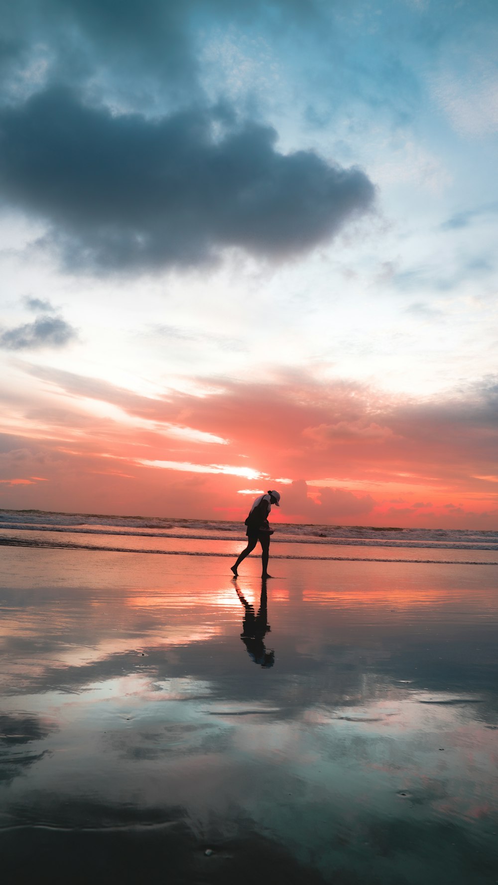 a person standing on a beach at sunset