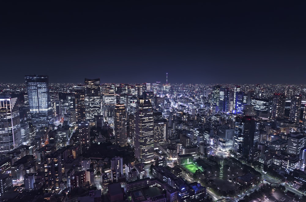 a view of a city at night from the top of a skyscraper