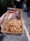A close-up of a hand holding a cardboard container filled with grilled meat and noodles, adorned with a small flag resembling the Thai national flag.