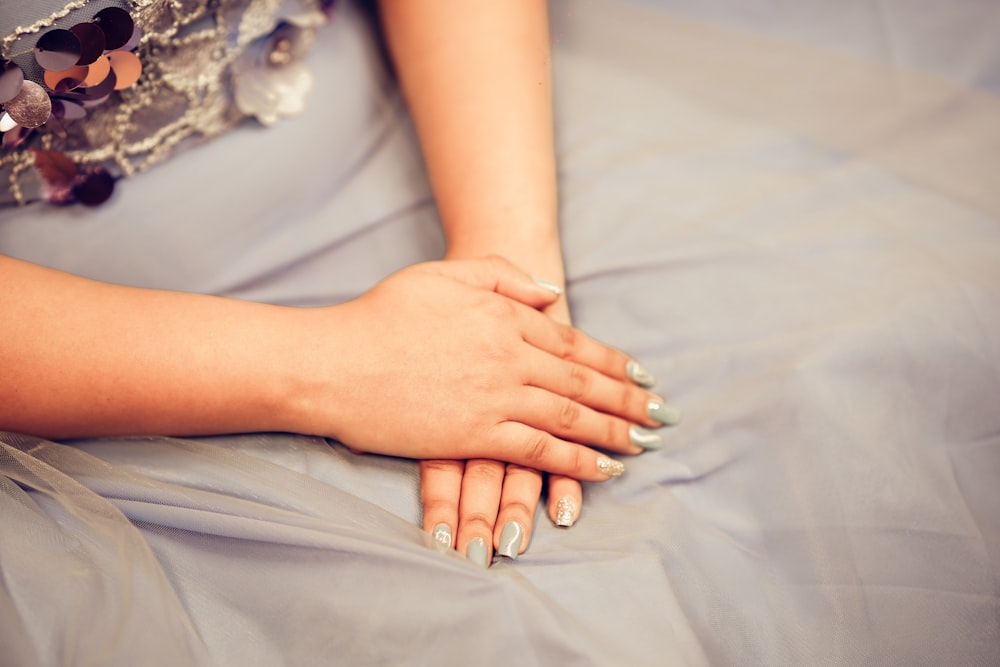 uma mulher em um vestido azul segurando suas mãos juntas