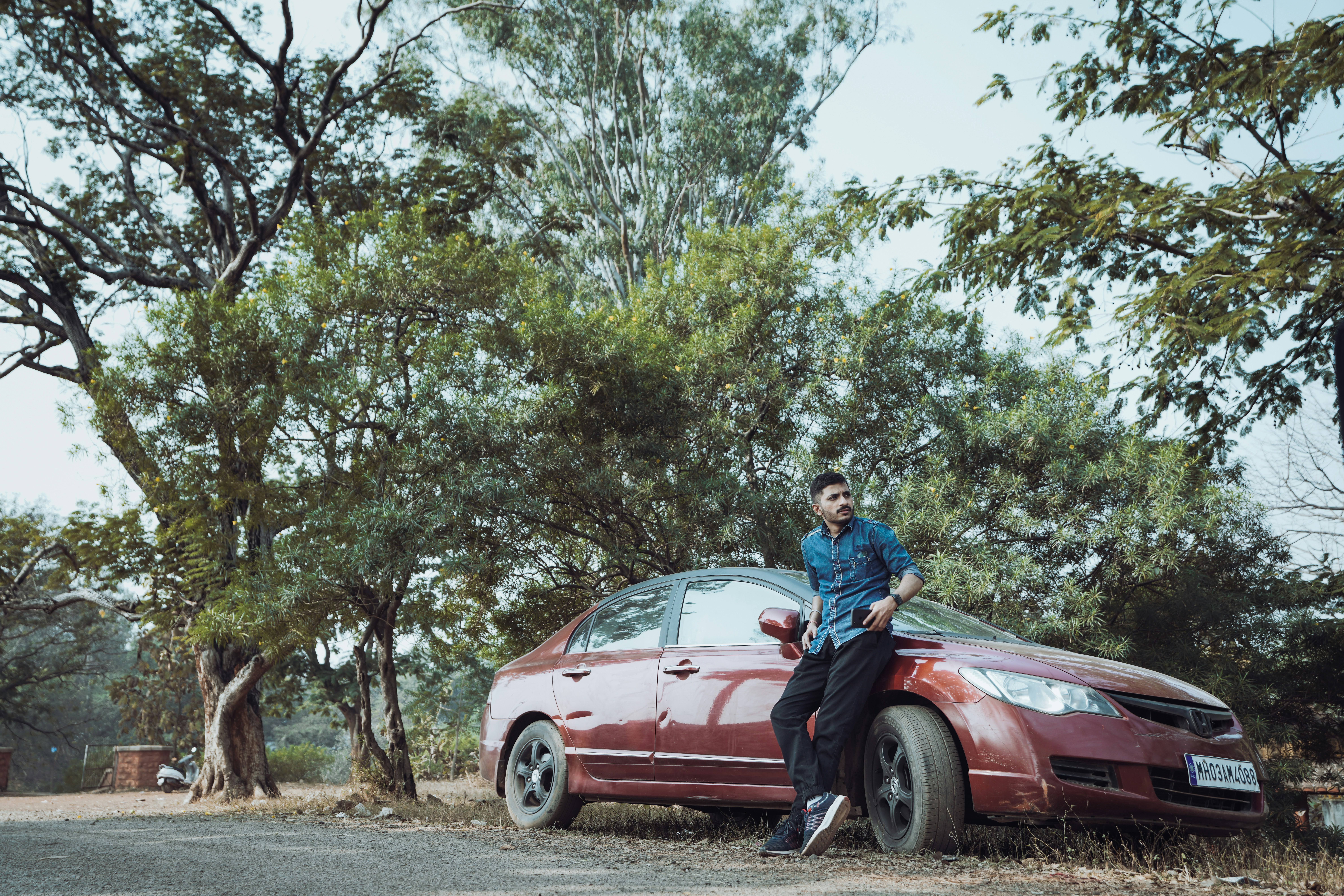 a man sitting on the hood of a red car