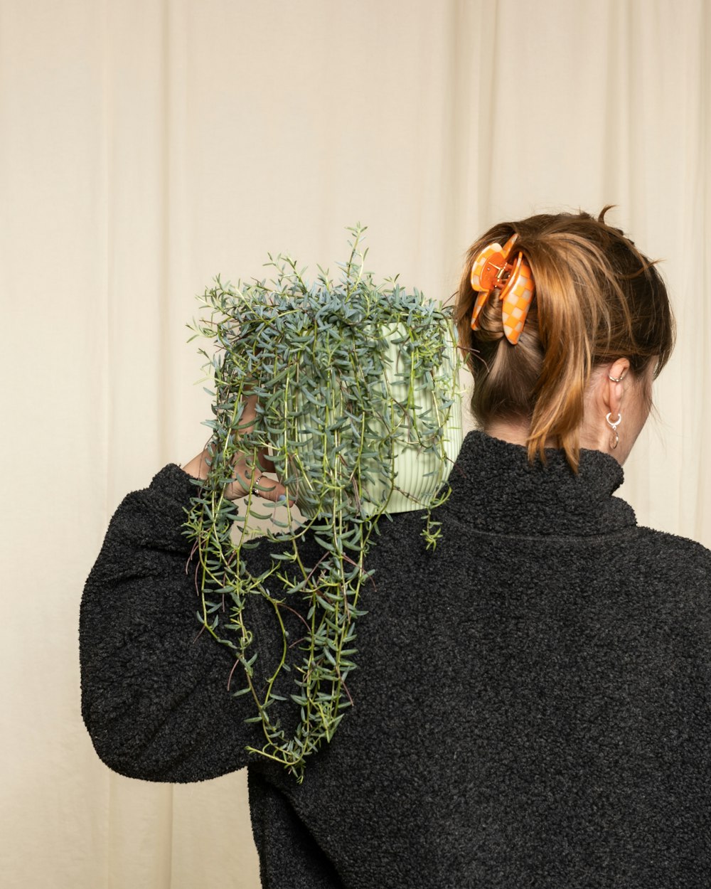 a woman holding a plant in front of her face