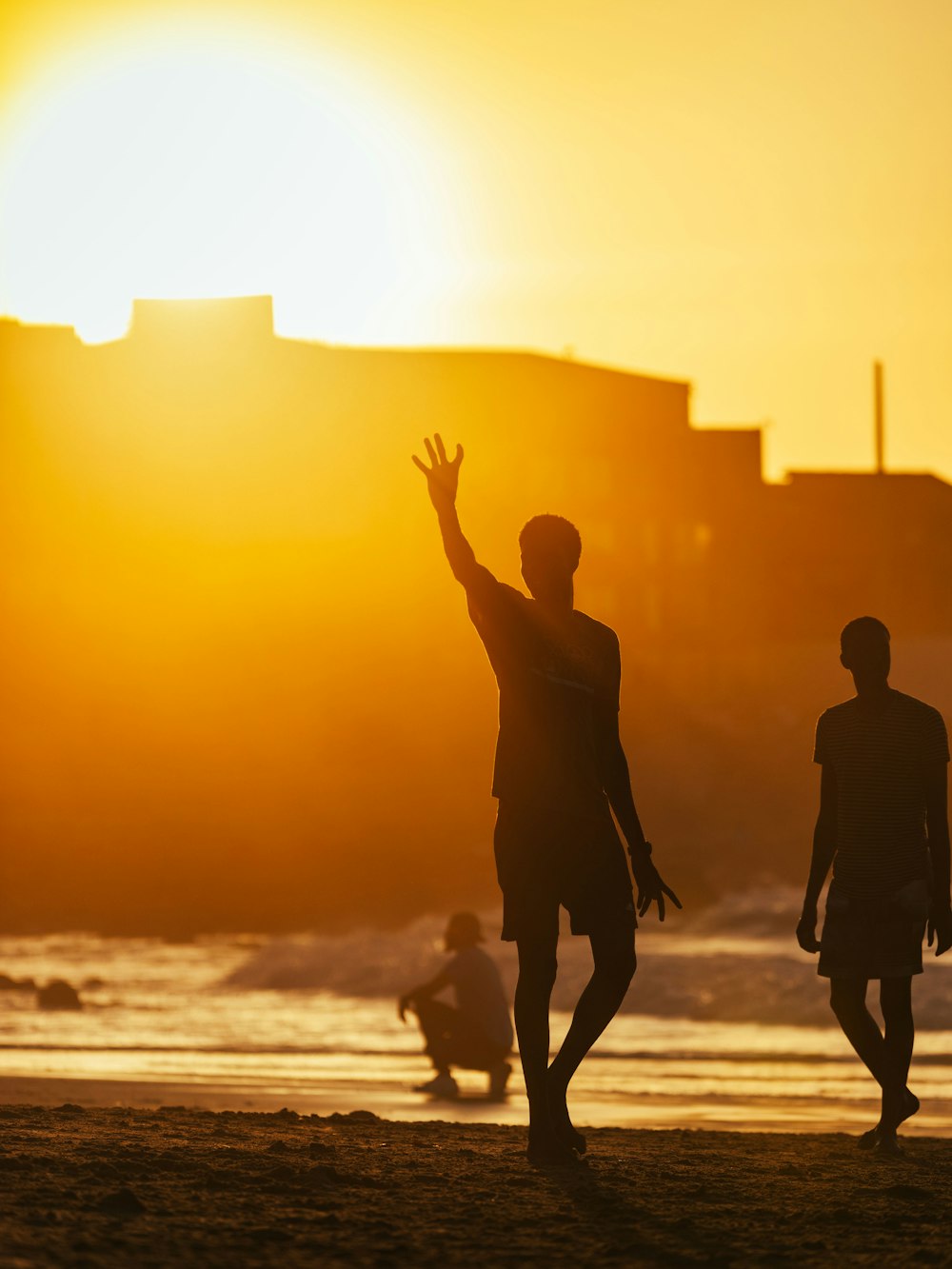 a couple of men standing on top of a sandy beach