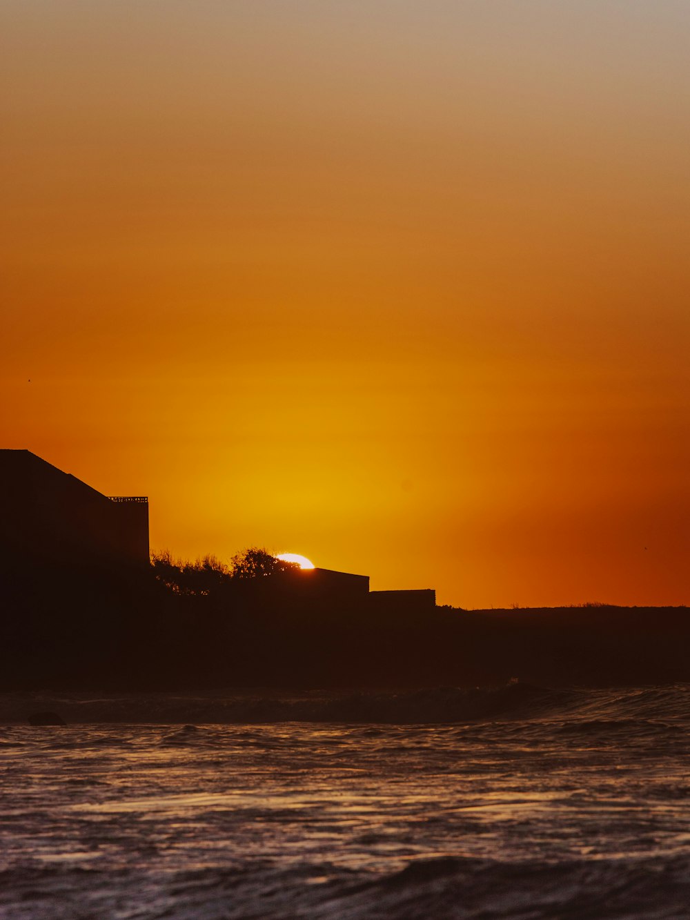 the sun is setting over the horizon of the ocean