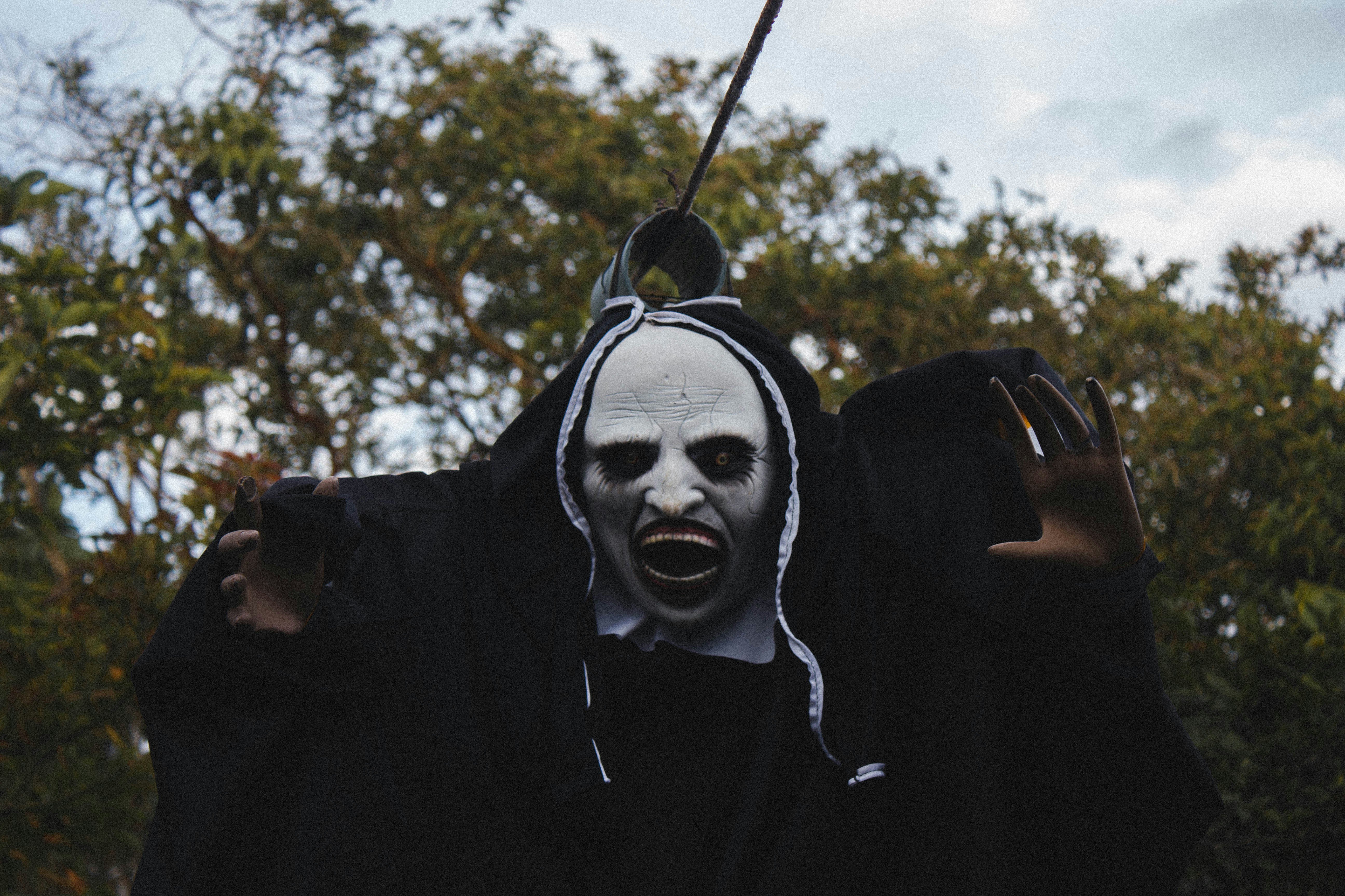 a person wearing a creepy mask and holding a string