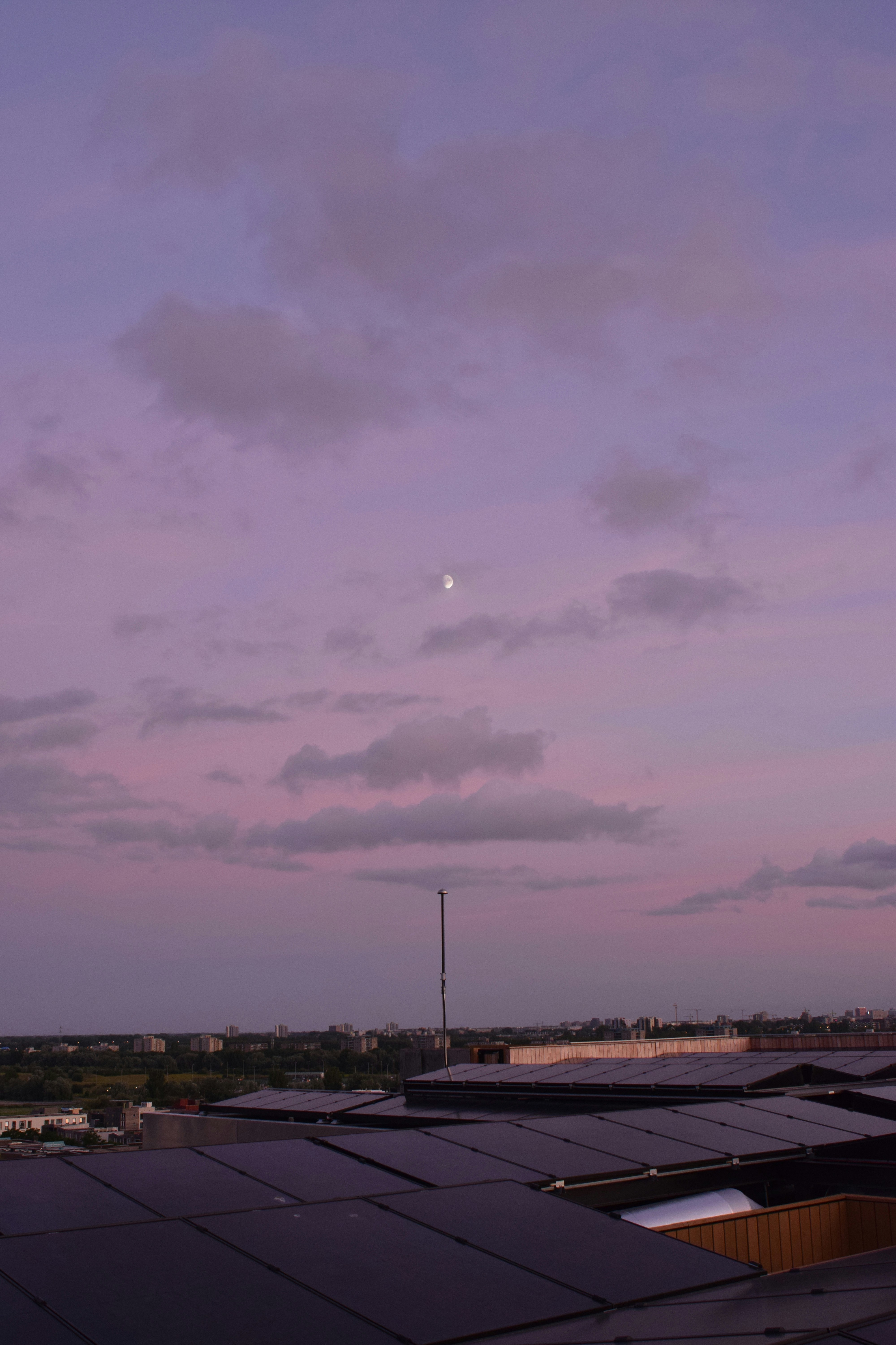 a purple sky with a half moon in the distance
