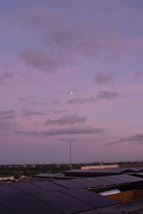 Sleek rooftop solar panels glowing softly under a twilight sky with electric blue and solar orange accents.