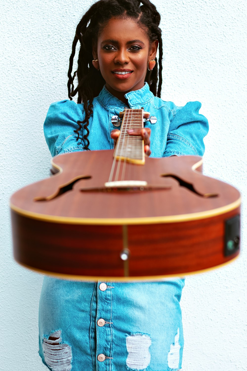a young girl holding a guitar in her hands