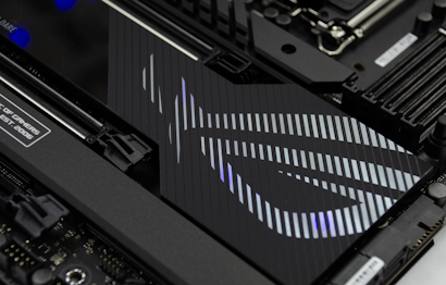 A close-up view of a computer motherboard featuring a stylish pattern and branding. The design includes diagonal lines and a logo, likely from a gaming or tech-related brand. The image highlights details of the circuitry and components.