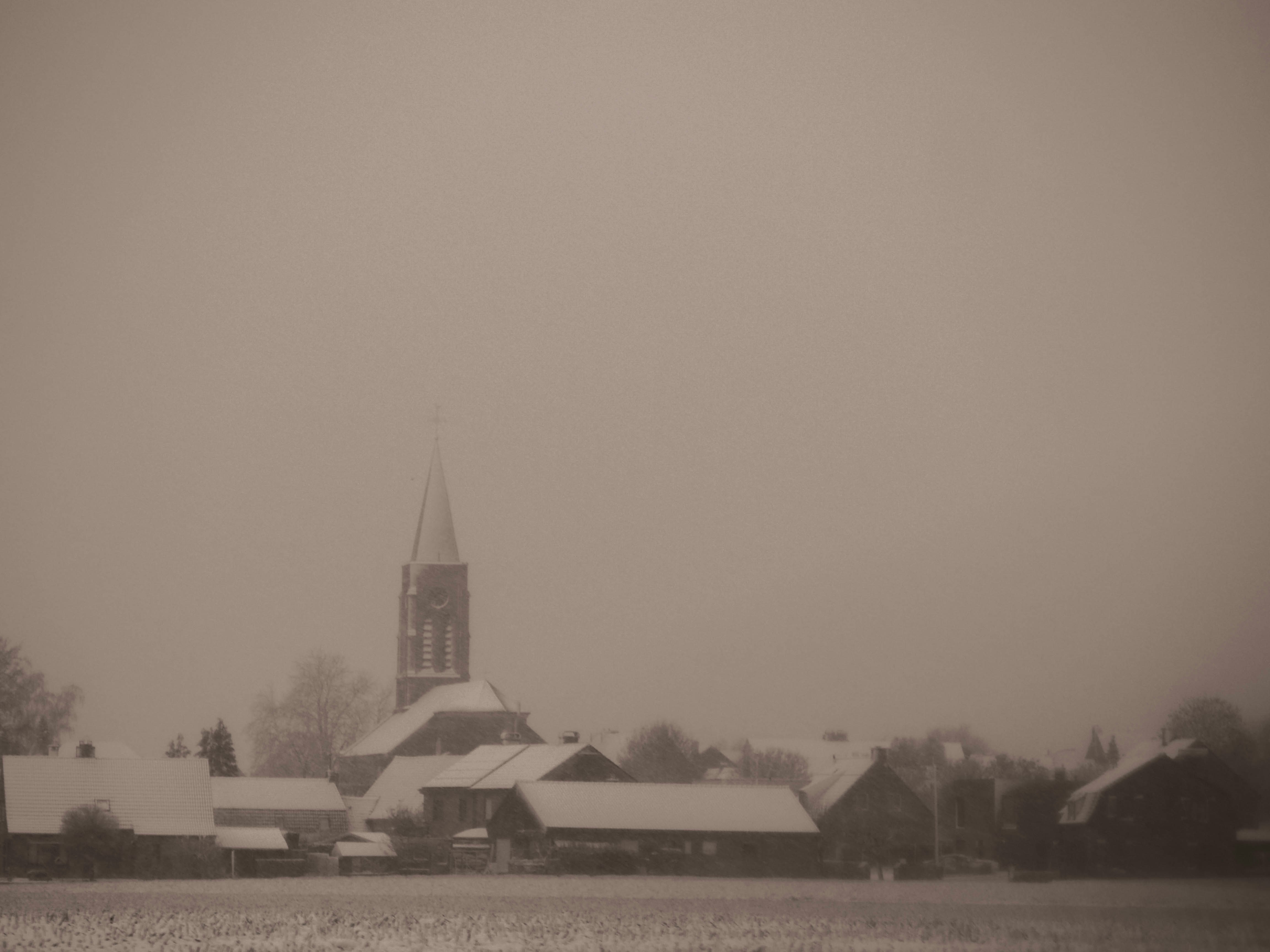 a black and white photo of a church in the snow
