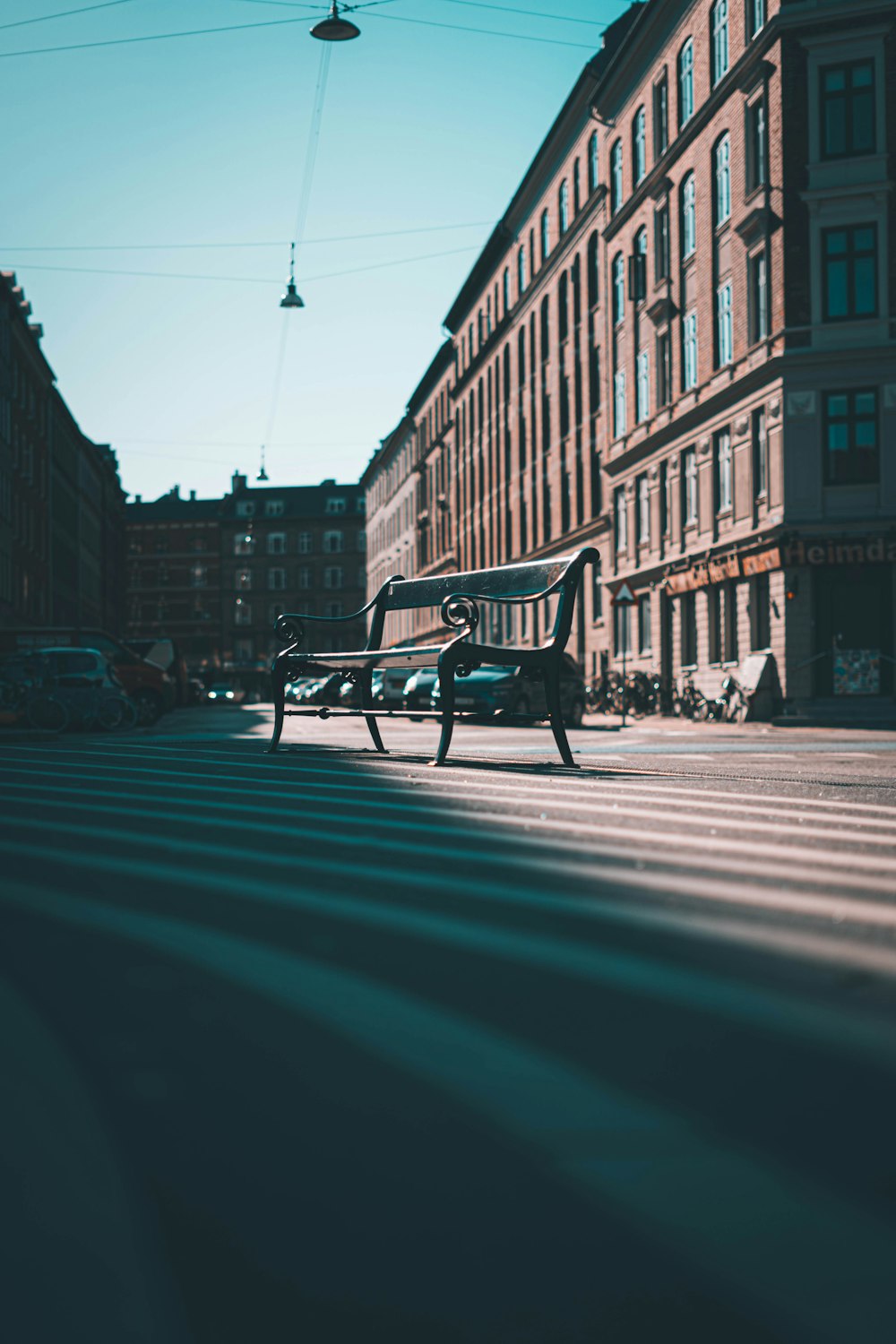 a park bench sitting in the middle of a street