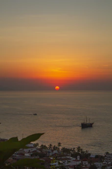 A vibrant photo of a sunset over Puerto Vallarta's coastline with a group enjoying a guided tour.